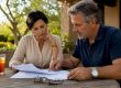 Couple reviewing home sale documents in kitchen