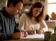 Couple signing postnuptial agreement at home