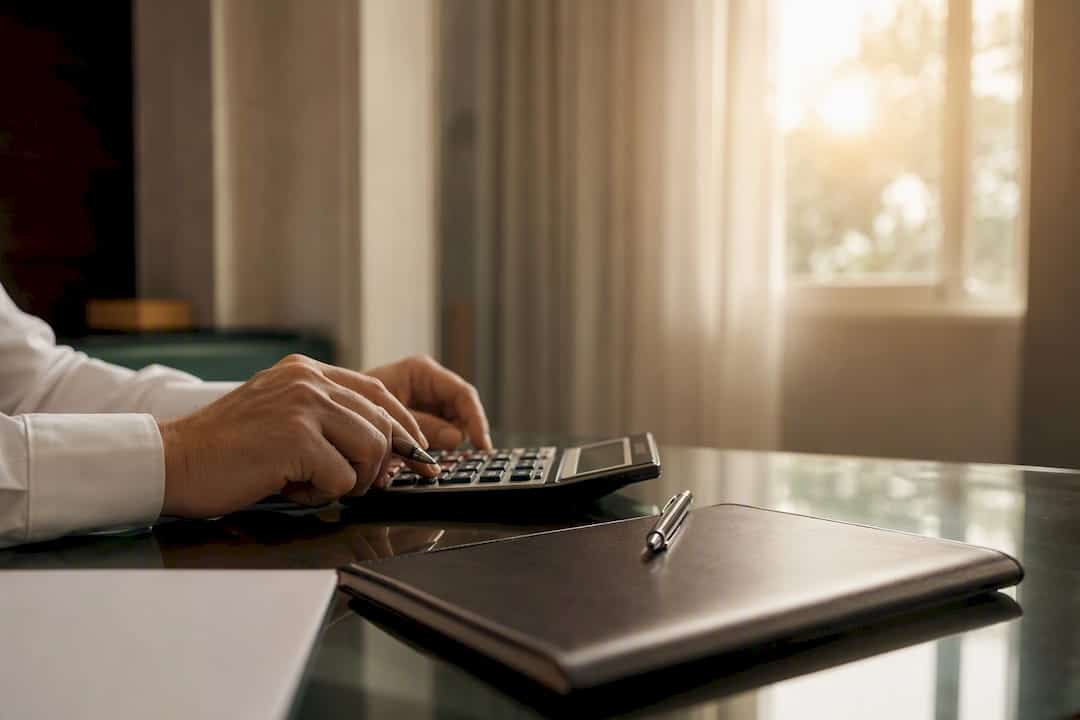 Hands placing calculator on desk during financial review
