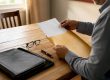Hands placing legal documents into envelope