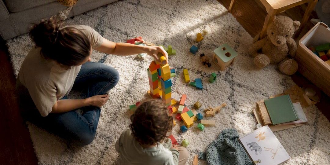 Parent’s hand moving toy car on table with calendar