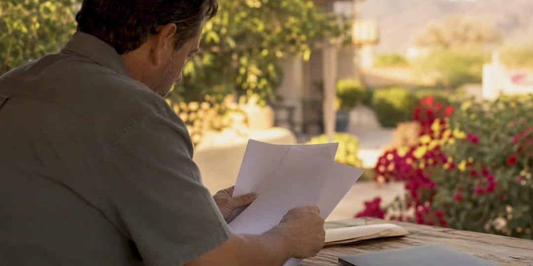 1787395427059_Hands-organizing-retirement-papers-on-table Hands organizing retirement papers on table