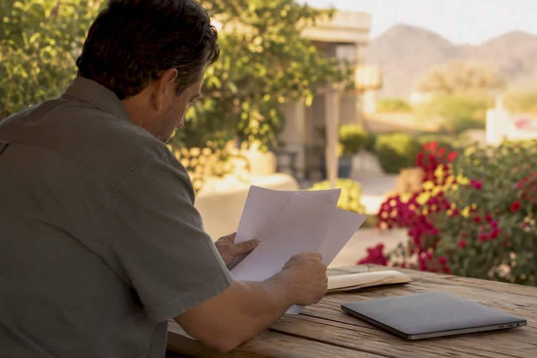 Hands organizing retirement papers on table