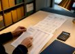 Hands reviewing financial records in courthouse archive